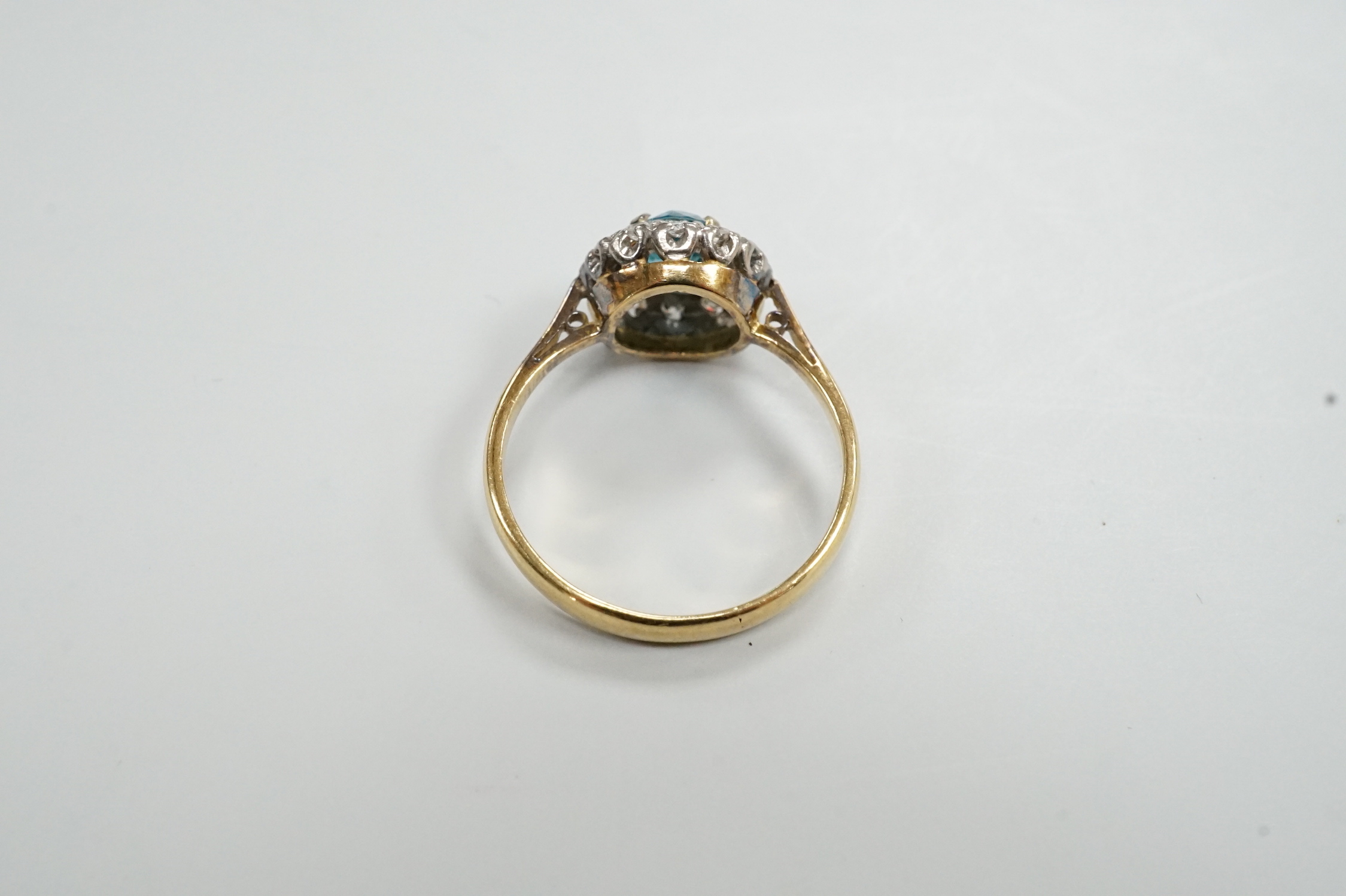 An 18ct & plat, blue zircon and illusion set diamond chip circular cluster ring, size M, gross weight 2.7 grams.